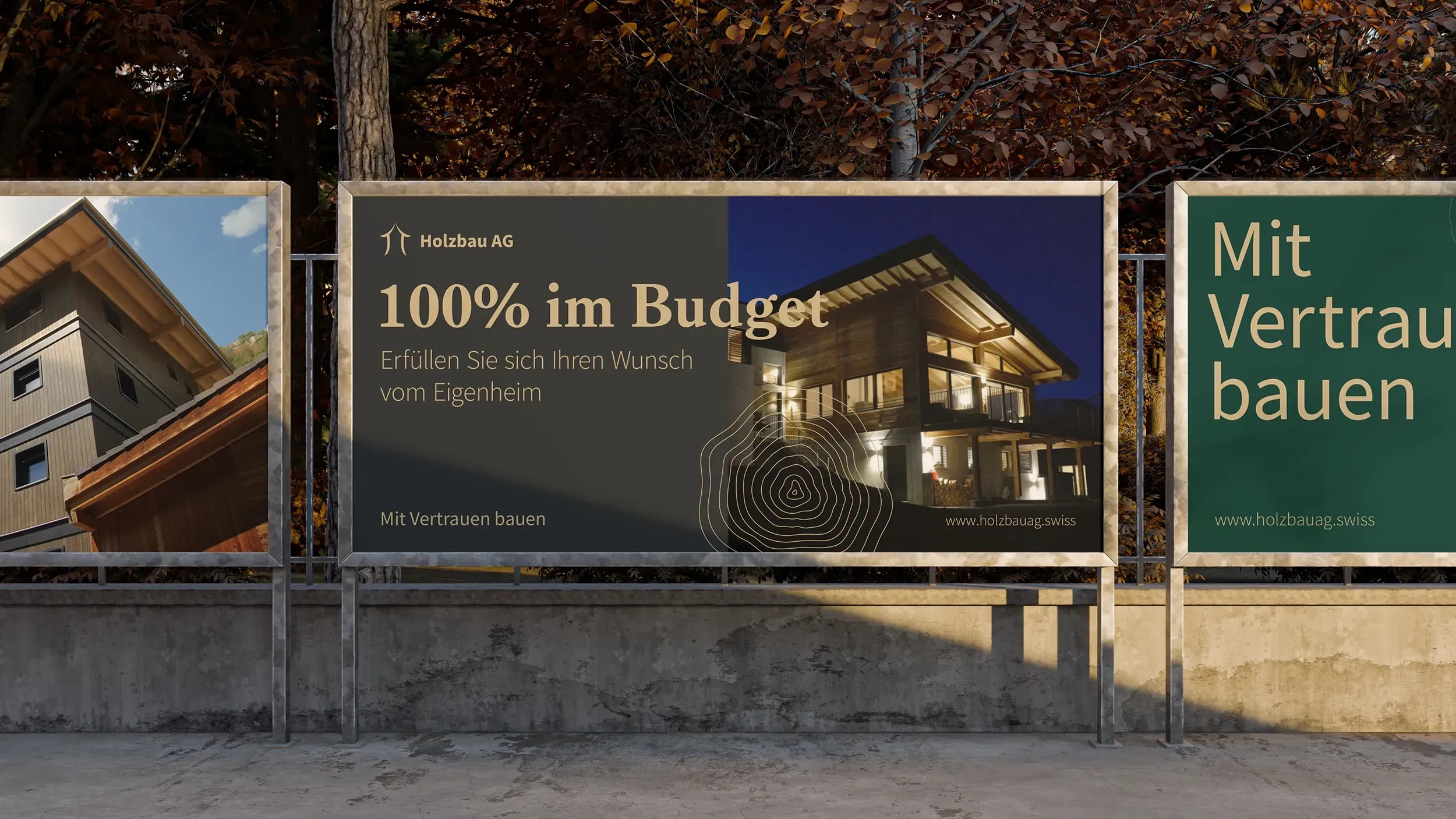 Plakatwand mit Kampagnenplakaten der Holzbau AG, darunter «100% im Budget» mit beleuchtetem Holzhaus bei Nacht und dem Claim «Mit Vertrauen bauen».