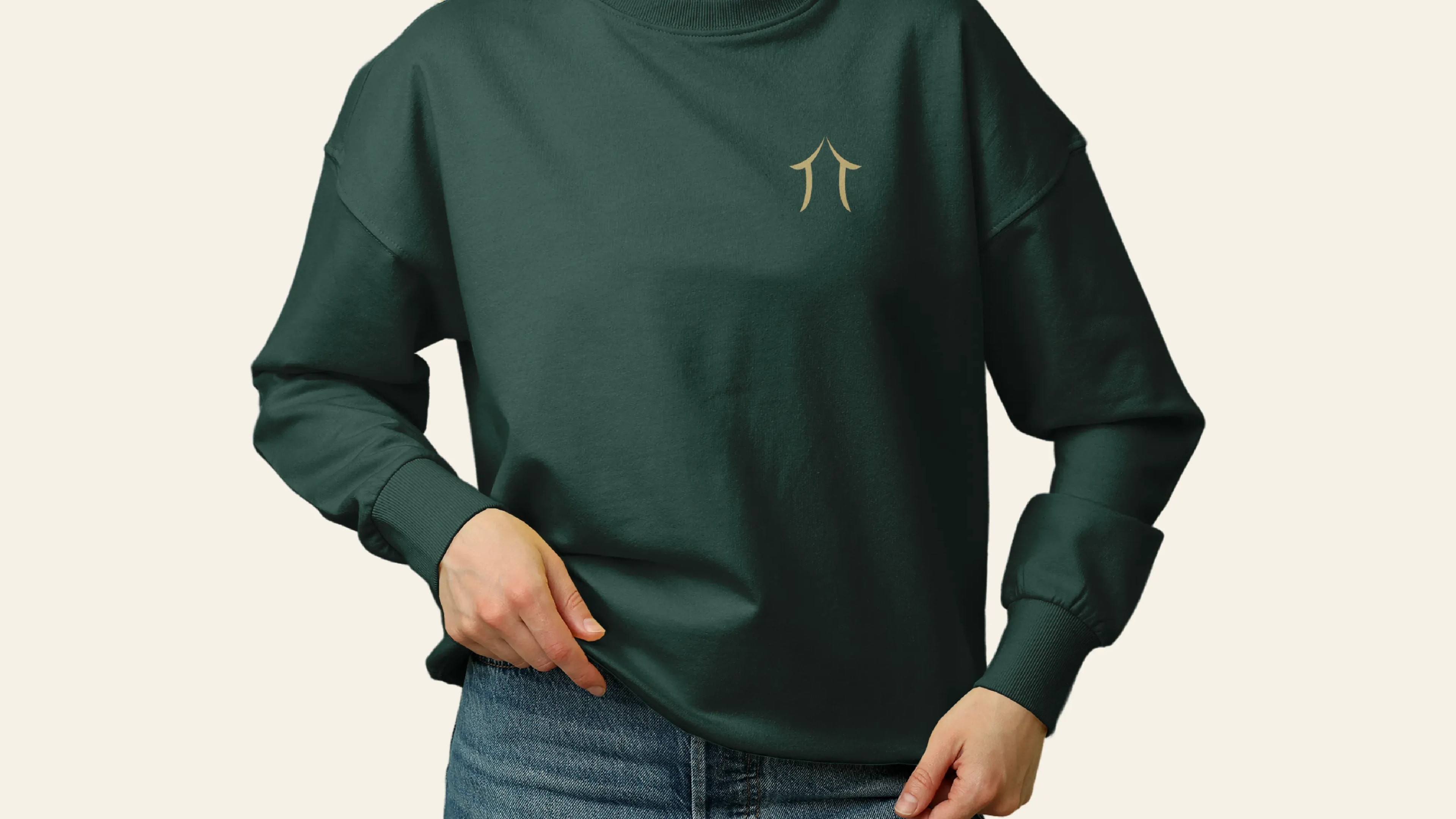 Dunkelgrüner Pullover mit goldfarben gesticktem Holzbau-AG-Signet auf der Brust als Teil der Firmenbekleidung.