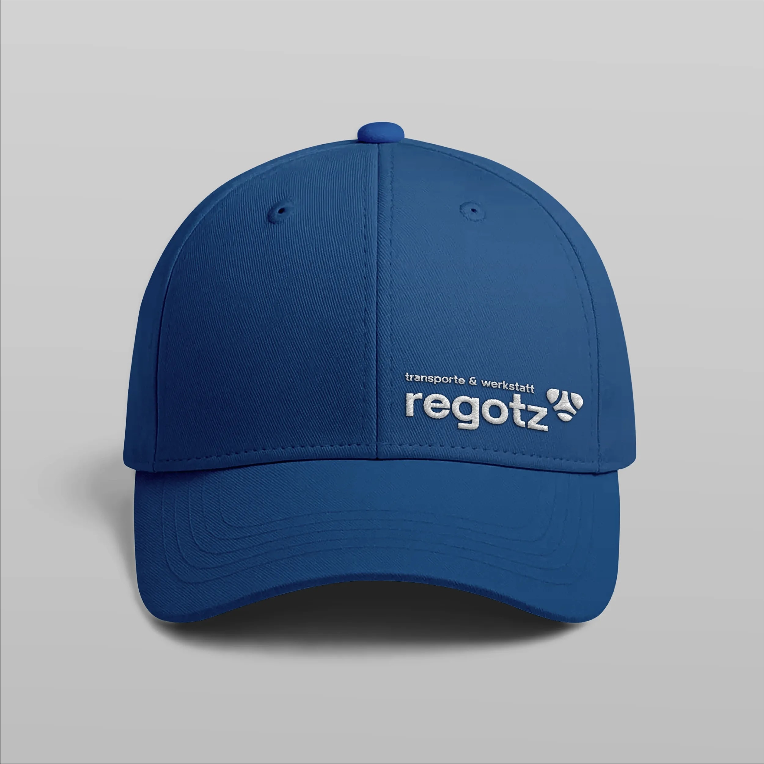 Blaue Cap mit gesticktem Logo von regotz transporte & werkstatt.