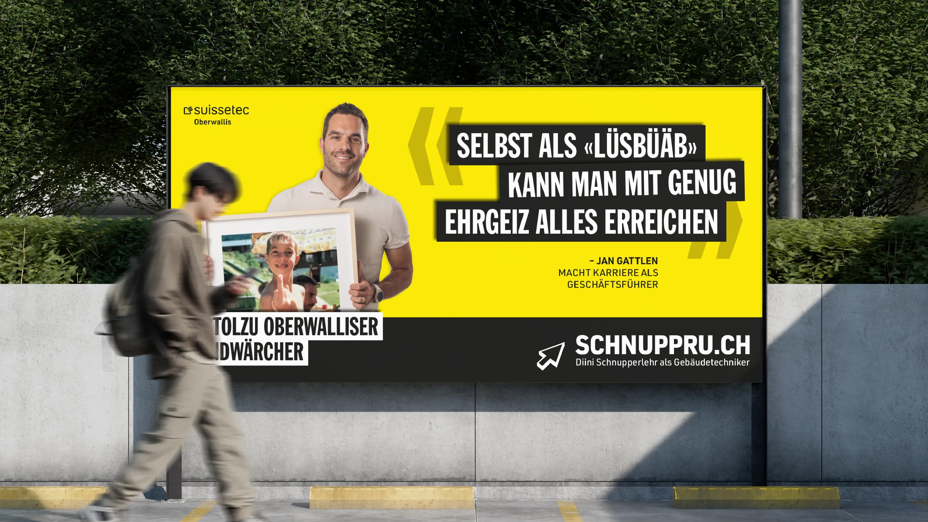 Grossflächenplakat der Kampagne «D'stolzu Oberwalliser Handwärcher»: Jan Gattlen hält ein Kinderfoto von sich, daneben sein Zitat auf gelbem Grund; eine Person geht vorbei.